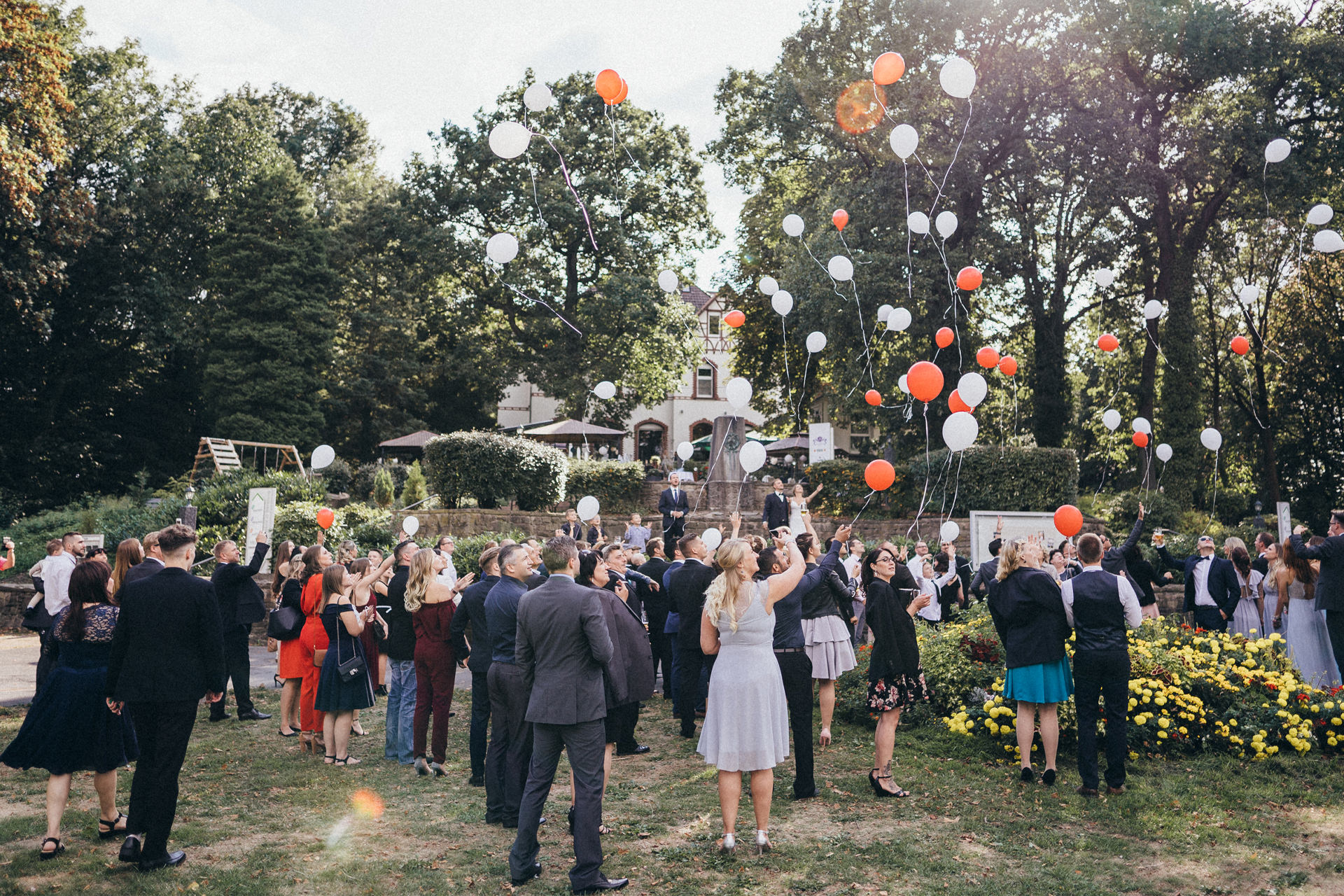 Hochzeitsgesellschaft lässt Ballons steigen - Rote und weiße Luftballons zur Hochzeitsfeier - Hochzeitsreportage in Dortmund - Chris Reuter Hochzeitsfotograf